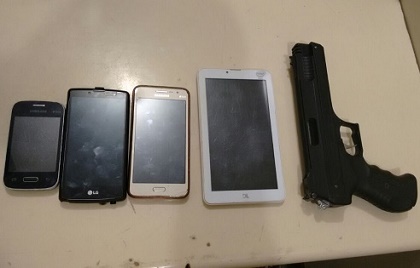 Foram apreendidos 4 celulares e uma pistola de brinquedo 