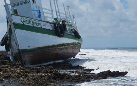 Lancha envolvida em acidente permanece presa aos arrecifes (Foto: Afonso Santana)